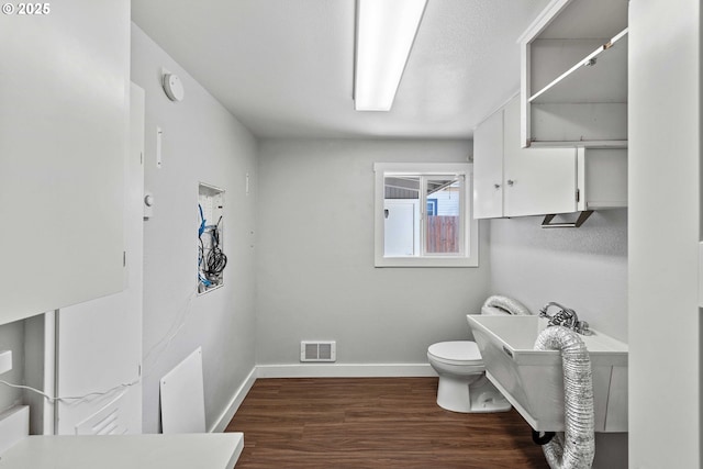 bathroom with visible vents, baseboards, wood finished floors, and toilet
