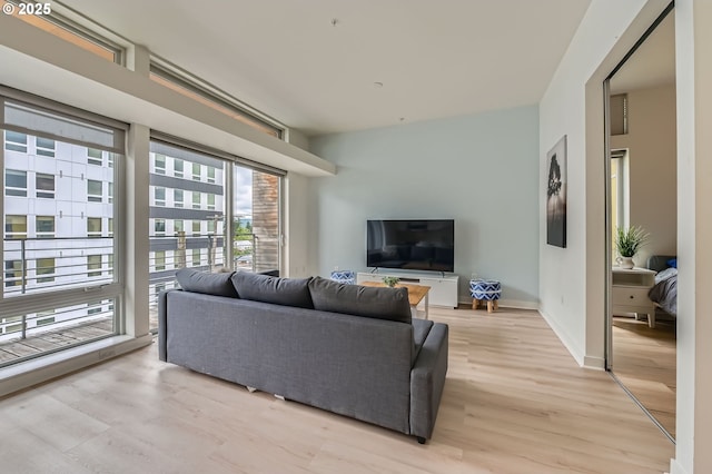 living area featuring light wood finished floors and baseboards