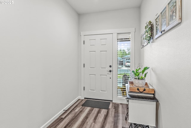 foyer entrance with wood finished floors and baseboards