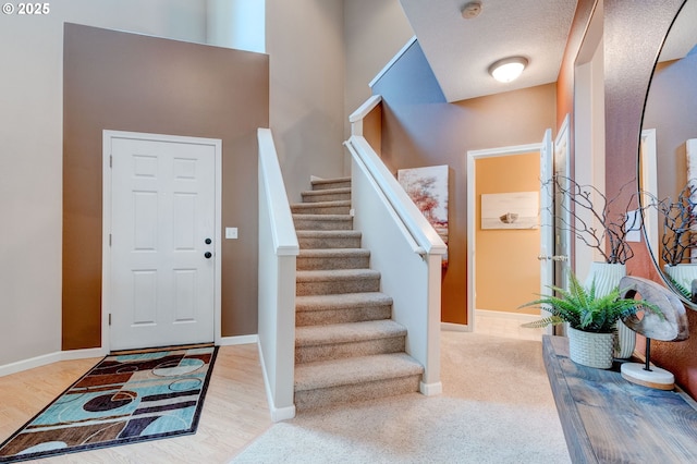 entrance foyer featuring stairway, wood finished floors, and baseboards