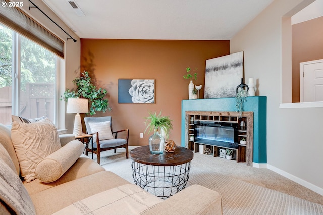 interior space with carpet, baseboards, and a glass covered fireplace