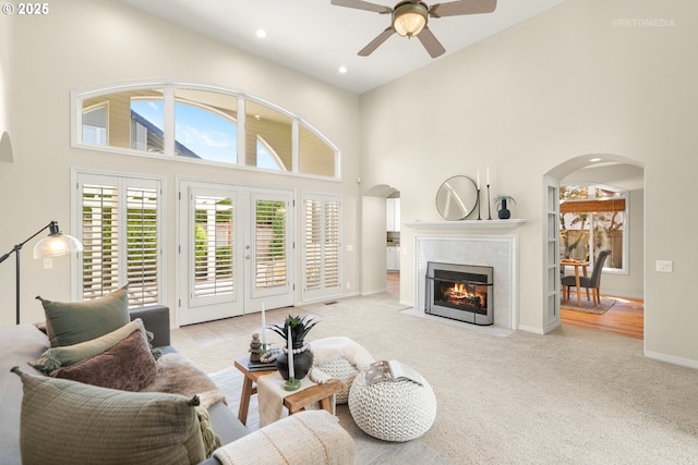 4182 NW Spoon Pl, Portland, OR 97229 - living room with a towering ceiling, carpet flooring, ceiling fan, arched walkways, and a premium fireplace