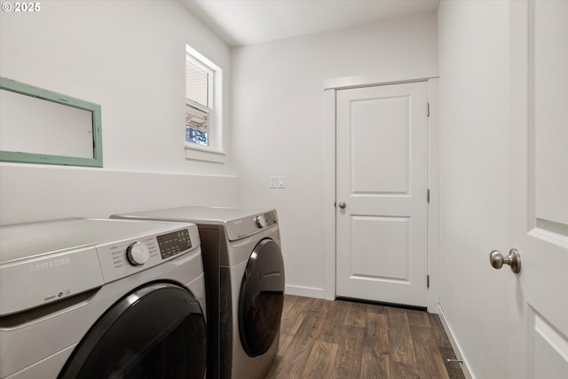 clothes washing area featuring dark wood-style floors, laundry area, washing machine and dryer, and baseboards