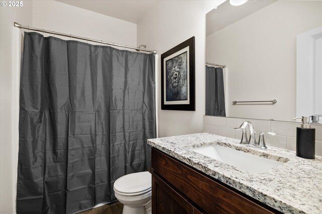 full bathroom with a shower with curtain, tasteful backsplash, toilet, and vanity