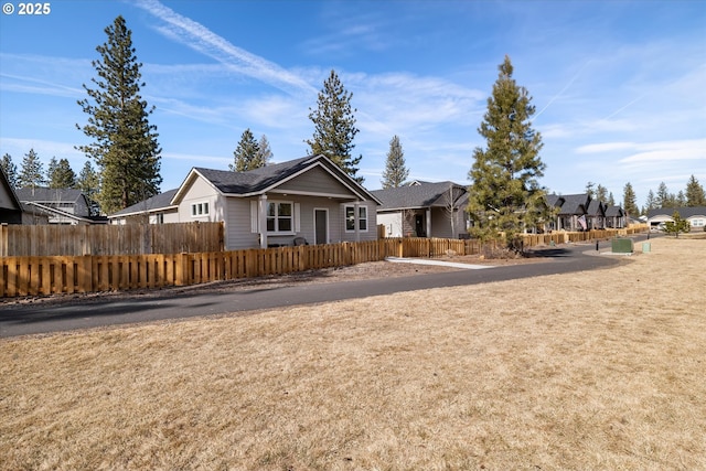 ranch-style home with a residential view and fence