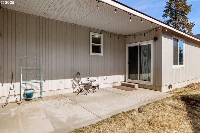 rear view of property featuring a patio and crawl space