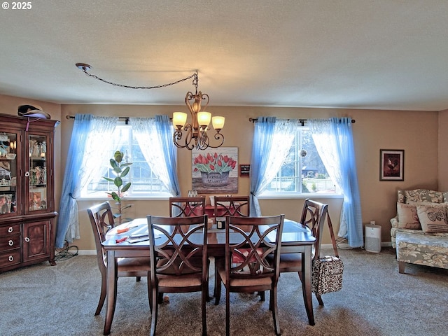 carpeted dining space with a notable chandelier, plenty of natural light, and a textured ceiling