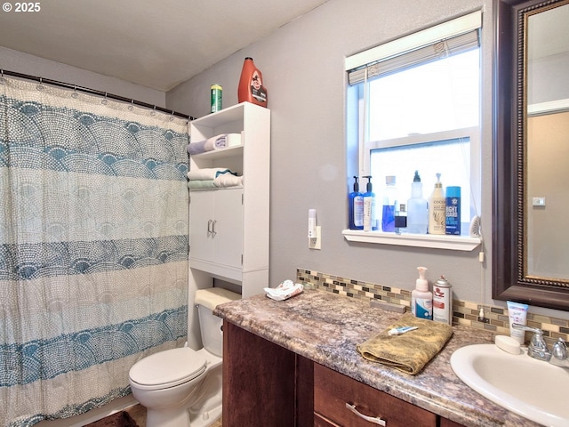 bathroom featuring vanity, backsplash, toilet, and walk in shower