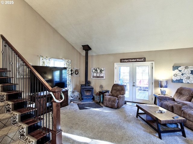 living room featuring french doors, carpet flooring, high vaulted ceiling, and a wood stove