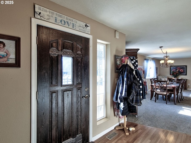 entryway featuring a notable chandelier and hardwood / wood-style flooring