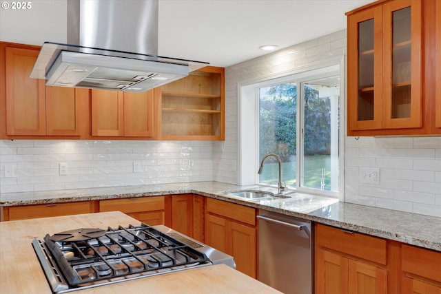 kitchen featuring sink, island range hood, light stone countertops, and appliances with stainless steel finishes