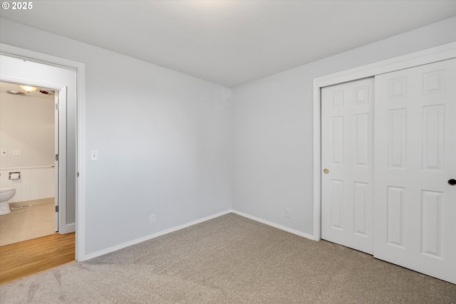 unfurnished bedroom featuring carpet flooring and a closet