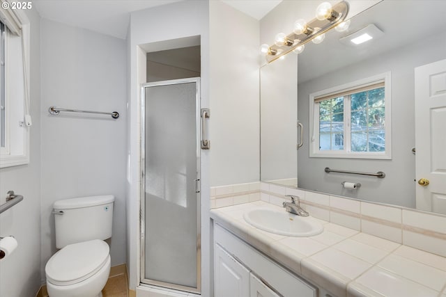 bathroom featuring vanity, toilet, and an enclosed shower