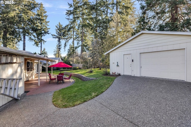 exterior space featuring a garage, a patio, and an outdoor structure