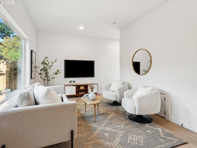 living area with wood finished floors, baseboards, and recessed lighting