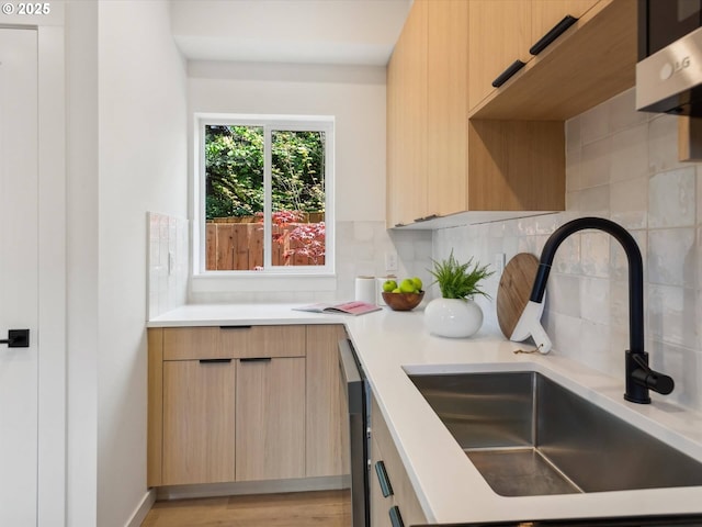 kitchen featuring a sink, modern cabinets, light brown cabinets, and light countertops