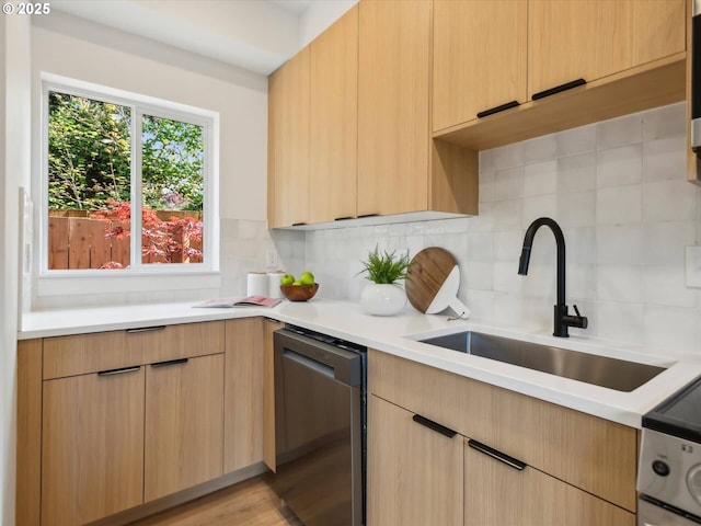 kitchen with dishwasher, a sink, light countertops, and backsplash
