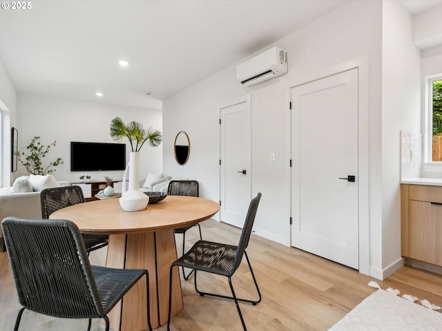 dining space with an AC wall unit, light wood-style flooring, and recessed lighting