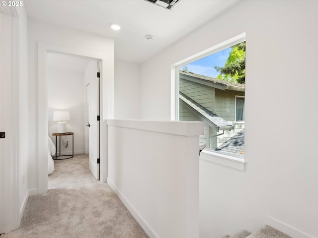 hall featuring carpet floors, an upstairs landing, baseboards, and recessed lighting