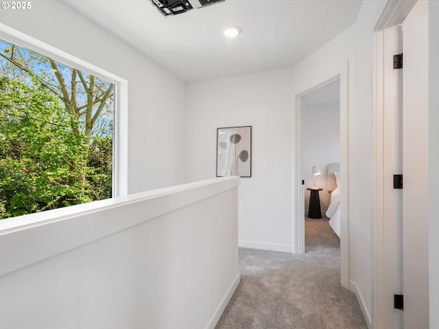 hallway featuring light carpet, baseboards, and recessed lighting