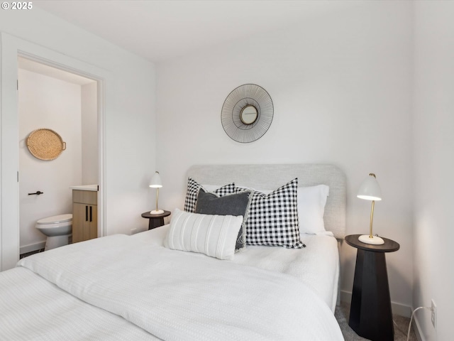 bedroom featuring connected bathroom and baseboards
