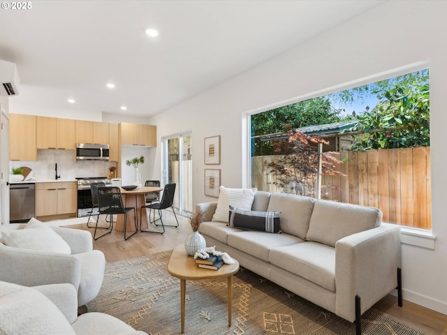 living room with light wood-style floors and recessed lighting