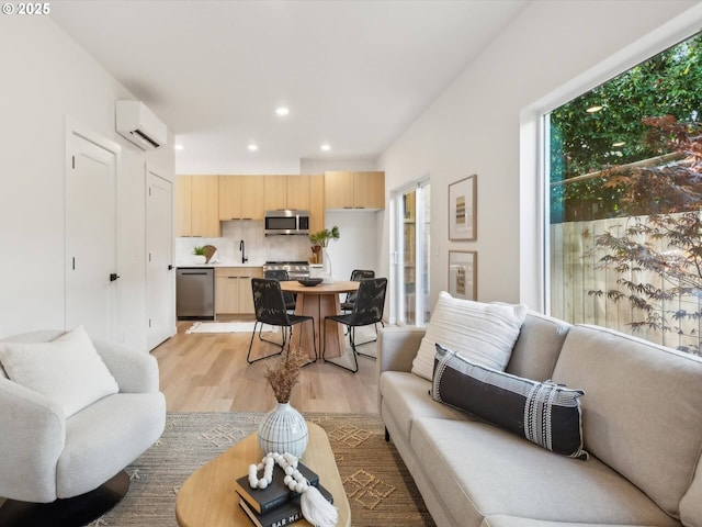 living area with light wood-style floors, a wall mounted AC, and recessed lighting