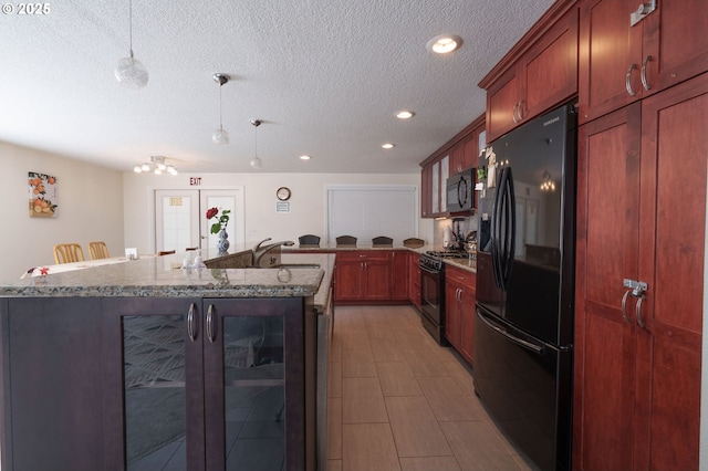 3584 NE Brogden St, Hillsboro, OR 97124 - kitchen with black appliances, a sink, a textured ceiling, stone counters, and decorative light fixtures