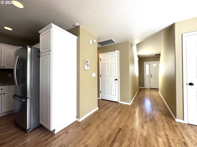 22000 SW Grahams Ferry Rd Unit C, Tualatin, OR 97062 - kitchen featuring freestanding refrigerator, light wood-style flooring, white cabinetry, baseboards, and a textured ceiling