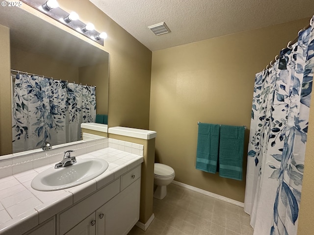 22000 SW Grahams Ferry Rd Unit C, Tualatin, OR 97062 - bathroom with toilet, vanity, a textured ceiling, baseboards, and tile patterned flooring