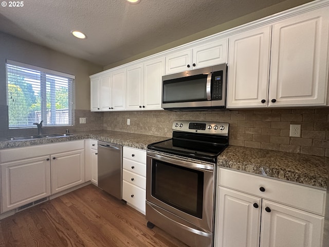 22000 SW Grahams Ferry Rd Unit C, Tualatin, OR 97062 - kitchen with appliances with stainless steel finishes, dark wood-style floors, white cabinets, a sink, and a textured ceiling