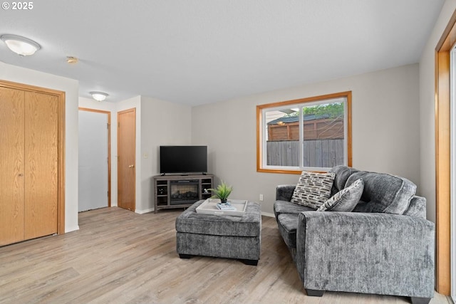 living area with light wood-style flooring and baseboards