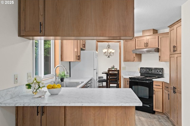 kitchen featuring black range with electric stovetop, a sink, under cabinet range hood, a peninsula, and light countertops