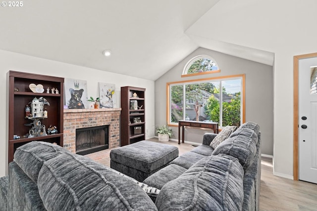 living area featuring a brick fireplace, lofted ceiling, baseboards, and light wood-style flooring