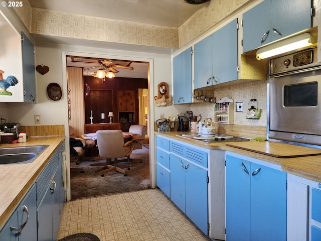 kitchen with ceiling fan, stainless steel oven, blue cabinets, and gas cooktop