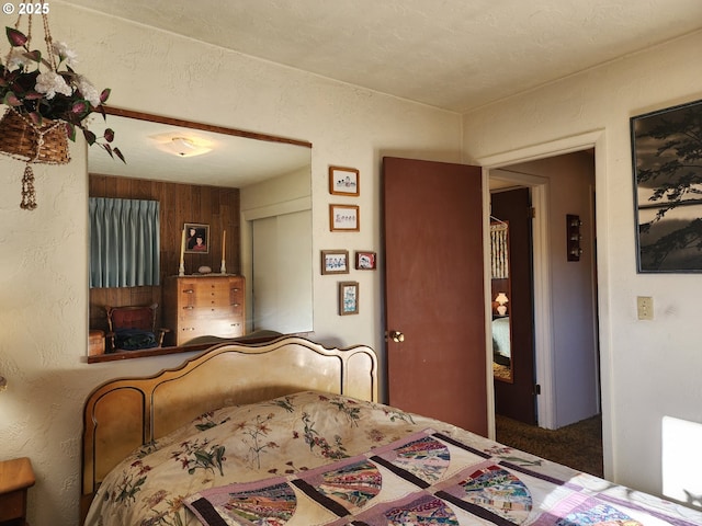 bedroom featuring carpet floors, a closet, and wood walls