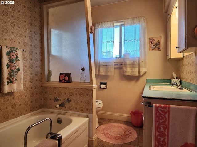 bathroom with a tub, toilet, vanity, and tile patterned flooring