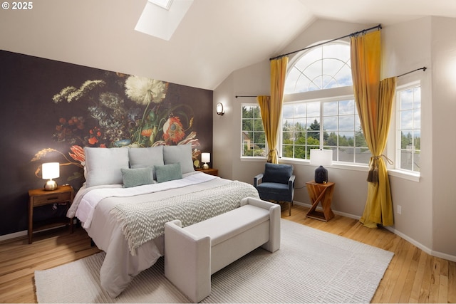 bedroom featuring a skylight, wood finished floors, vaulted ceiling, and baseboards