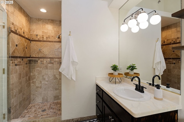 bathroom featuring tiled shower and vanity