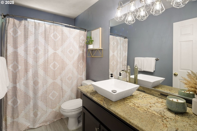 bathroom with wood finished floors, toilet, a chandelier, vanity, and a shower with shower curtain