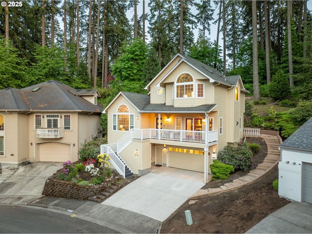 view of front of home featuring a garage, driveway, stairs, and a porch