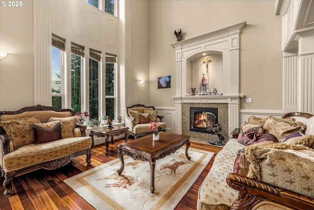 12712 SE 137th Dr, Happy Valley, OR 97086 - living room featuring a high ceiling, dark wood finished floors, a wainscoted wall, a tiled fireplace, and a decorative wall