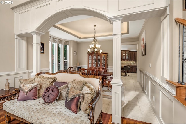 12712 SE 137th Dr, Happy Valley, OR 97086 - living room with ornate columns, a decorative wall, light tile patterned flooring, a raised ceiling, and wainscoting