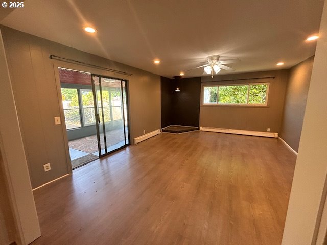 960 E Main St, Hillsboro, OR 97123 - empty room featuring wood finished floors, a baseboard heating unit, ceiling fan, and recessed lighting