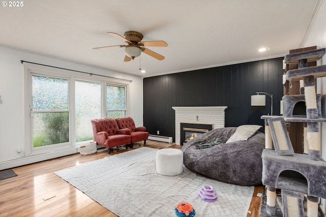 960 E Main St, Hillsboro, OR 97123 - living area with a baseboard radiator, ceiling fan, a glass covered fireplace, wood finished floors, and recessed lighting