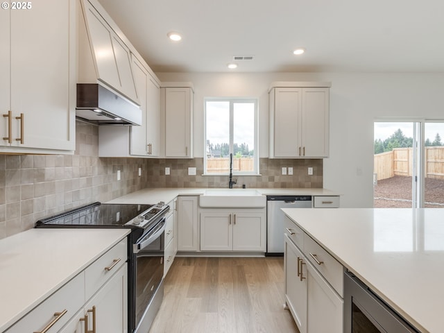 360 NW 29th Way, Battle Ground, WA 98604 - kitchen with stainless steel dishwasher, electric range oven, a sink, light wood finished floors, and light countertops