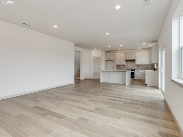 360 NW 29th Way, Battle Ground, WA 98604 - unfurnished living room featuring light wood-type flooring, recessed lighting, baseboards, and a sink