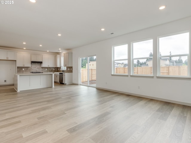 360 NW 29th Way, Battle Ground, WA 98604 - unfurnished living room featuring recessed lighting, light wood-type flooring, baseboards, and a sink