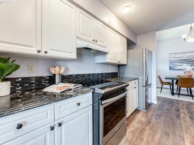 2001 E Evergreen Blvd, Vancouver, WA 98661 - kitchen featuring appliances with stainless steel finishes, white cabinetry, light wood-type flooring, under cabinet range hood, and dark stone countertops