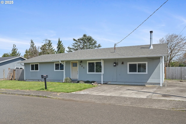 ranch-style home featuring fence, a shingled roof, and a front yard